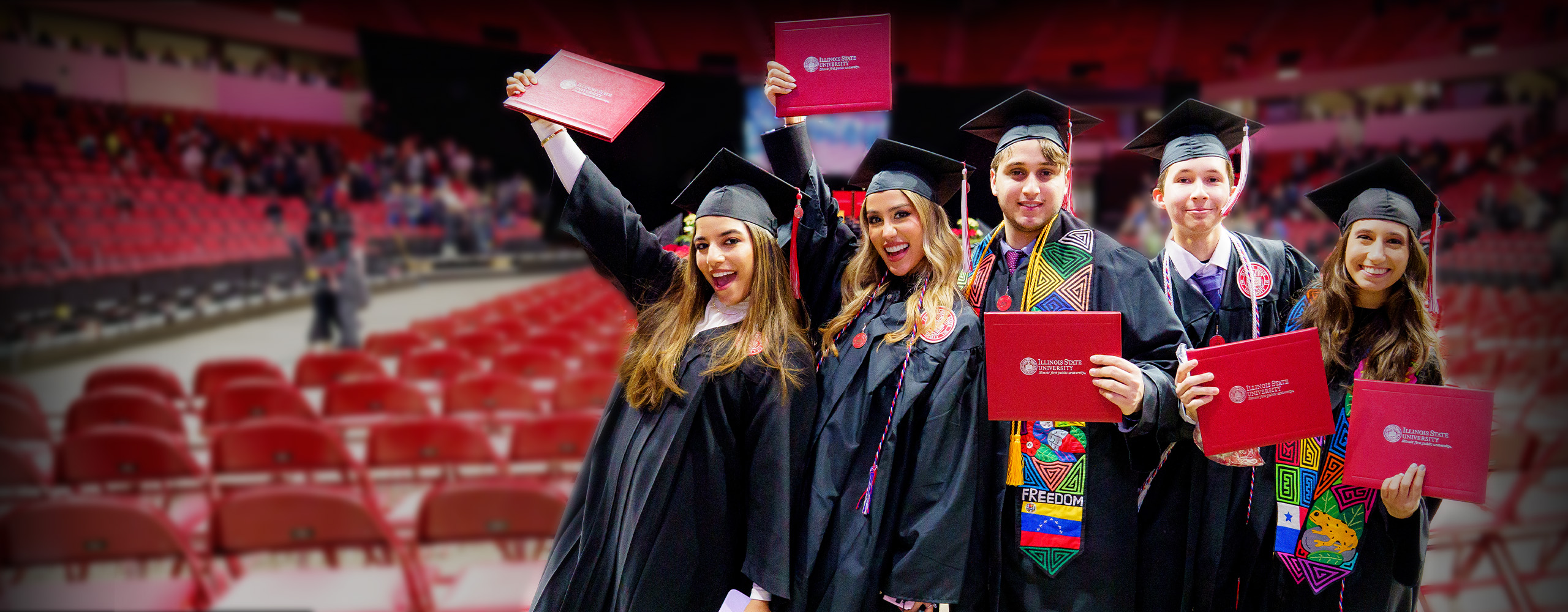 Four ISU graduates posing with their diplomas.