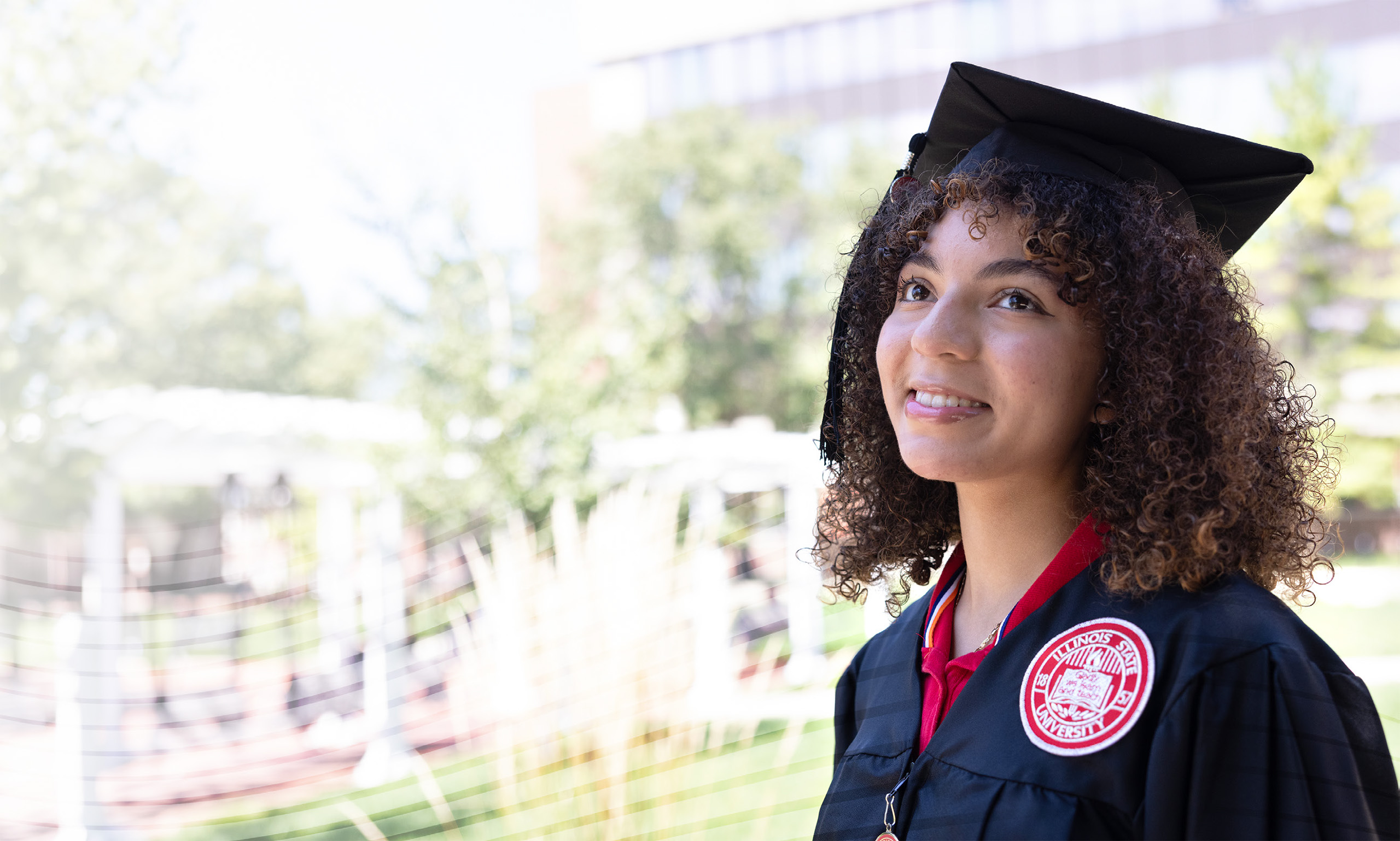ISU graduate looking hopeful with ISU quad in the background.