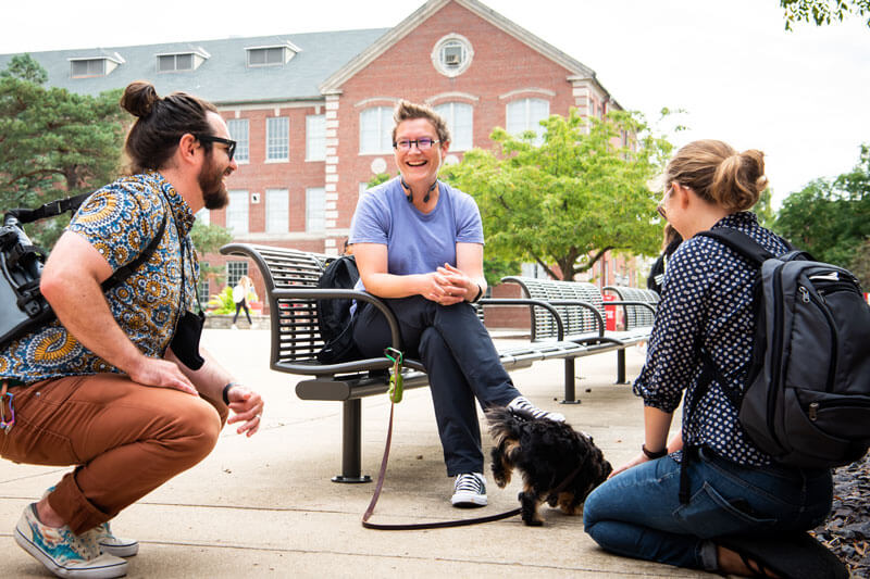 Students stop to visit with a professor on the quad.