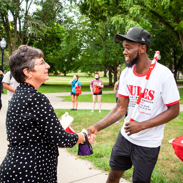 President Kinzy shakes the hand of a student at Festival ISU.
